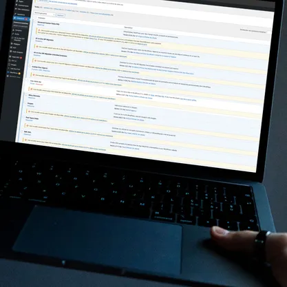 Photo d'une personne sur un ordinateur mettant a jour des plugins wordpress 